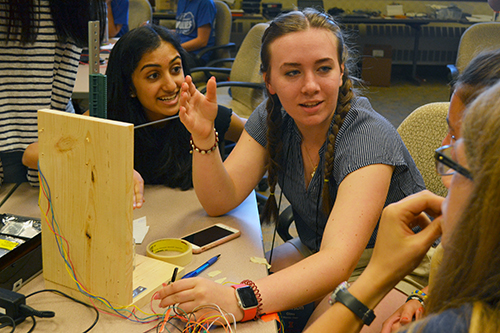 Madison Olms (center) chats with her teammates about their 3D printer.